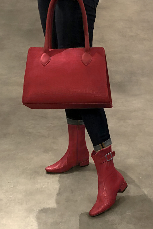 Scarlet red ankle boots with buckles on the sides. Round toe. Low